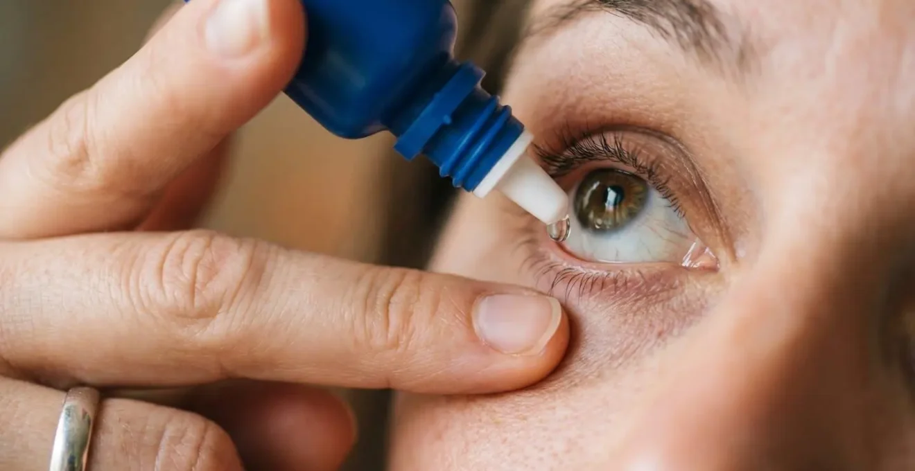 Macro close-up of proper eye drop application technique showing hand positioning and lower eyelid pocket formation