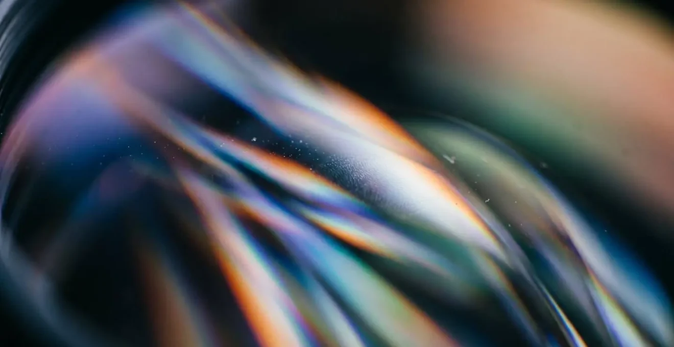 Macro photograph showing abstract light refraction through curved glass surface illustrating optical distortion